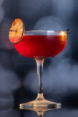 Limon tekeriyle süslenmiş güzel bir kozmopolit kokteyli.