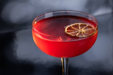 Limon tekeriyle süslenmiş güzel bir kozmopolit kokteyli.