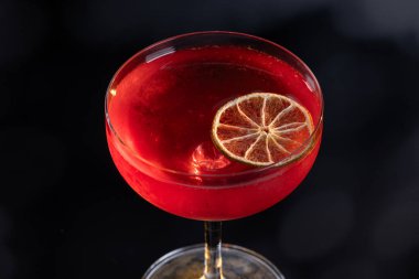 Limon tekeriyle süslenmiş güzel bir kozmopolit kokteyli.