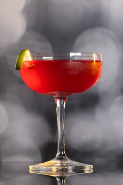 Güzel kozmopolit kokteyli limon kıvrımı ve dramatik ışıklandırmayla süslenmiş.