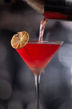 Limon tekeriyle süslenmiş güzel bir kozmopolit kokteyli.