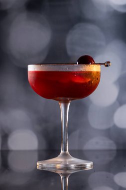 Manhattan kokteyli garnitür olarak Bordeaux vişneli ve portakallı.