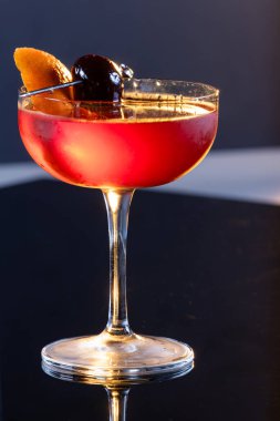 Manhattan kokteyli garnitür olarak Bordeaux vişneli ve portakallı.