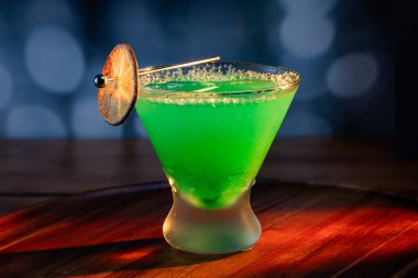 Ahşap tepside canlı renkte, sert dramatik ışıklandırmalı klasik yeşil içecek.