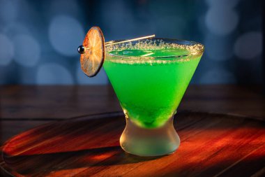 Ahşap tepside canlı renkte, sert dramatik ışıklandırmalı klasik yeşil içecek.