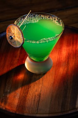 Ahşap tepside canlı renkte, sert dramatik ışıklandırmalı klasik yeşil içecek.