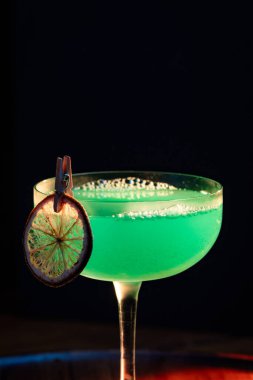 Ahşap tepside canlı renkte, sert dramatik ışıklandırmalı klasik yeşil içecek.