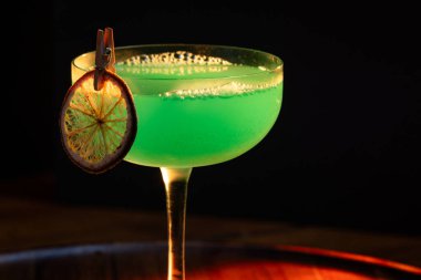 Ahşap tepside canlı renkte, sert dramatik ışıklandırmalı klasik yeşil içecek.