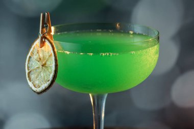 Ahşap tepside canlı renkte, sert dramatik ışıklandırmalı klasik yeşil içecek.