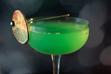 Ahşap tepside canlı renkte, sert dramatik ışıklandırmalı klasik yeşil içecek.