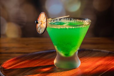 Ahşap tepside canlı renkte, sert dramatik ışıklandırmalı klasik yeşil içecek.