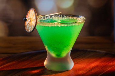 Ahşap tepside canlı renkte, sert dramatik ışıklandırmalı klasik yeşil içecek.