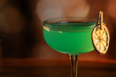 Ahşap tepside canlı renkte, sert dramatik ışıklandırmalı klasik yeşil içecek.