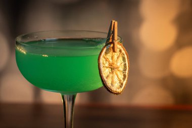 Ahşap tepside canlı renkte, sert dramatik ışıklandırmalı klasik yeşil içecek.