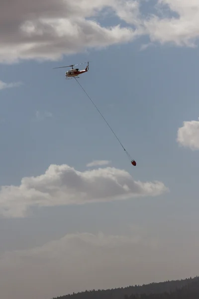 Brandbekämpning helikopter med en vattenhink — Stockfoto