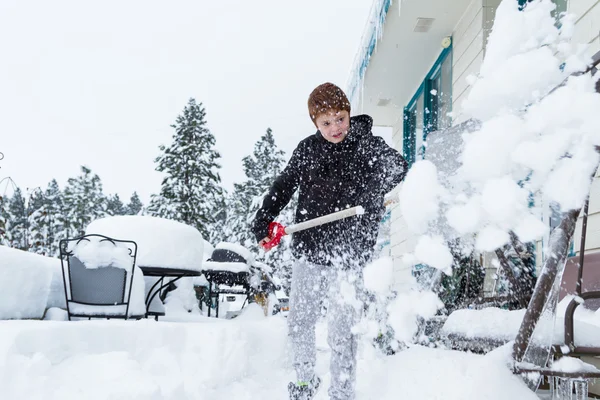 Giovane ragazzo spalare la neve — Foto Stock