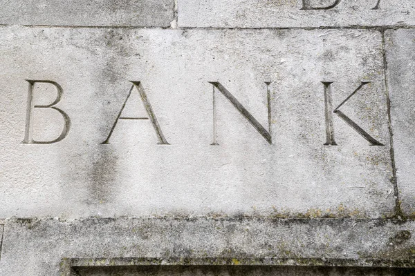 Elegant bank sign carved in to stone wall