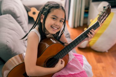 Akustik gitar çalmayı öğrenme mutlu gülümseyen kız