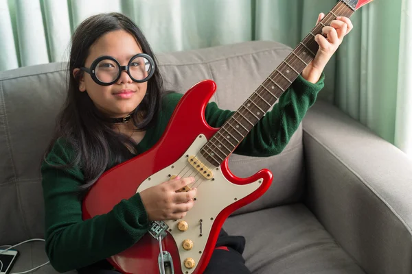 Fille souriante heureuse, apprenant à jouer de la guitare électrique — Photo