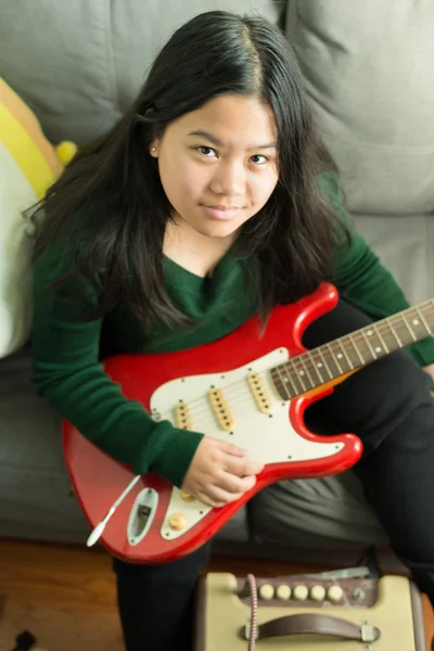 Fille souriante heureuse, apprenant à jouer de la guitare électrique — Photo