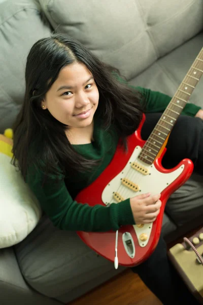 Felice ragazza sorridente, imparare a suonare la chitarra elettrica — Foto Stock