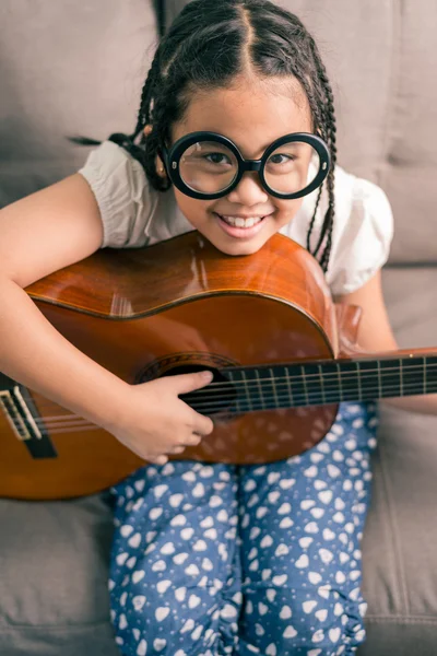 Glada leende flicka lära sig spela akustisk gitarr — Stockfoto