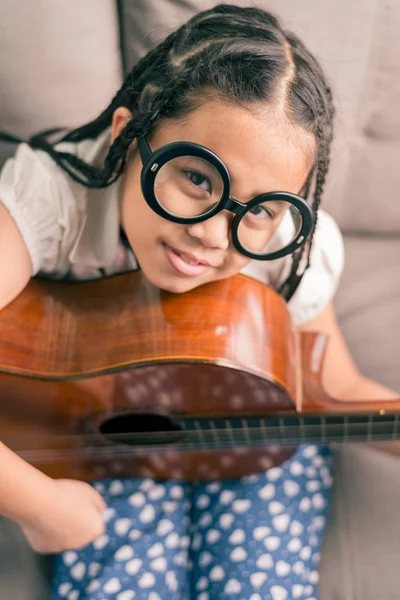 Glada leende flicka lära sig spela akustisk gitarr — Stockfoto