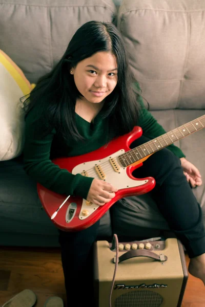 Fille souriante heureuse, apprenant à jouer de la guitare électrique — Photo