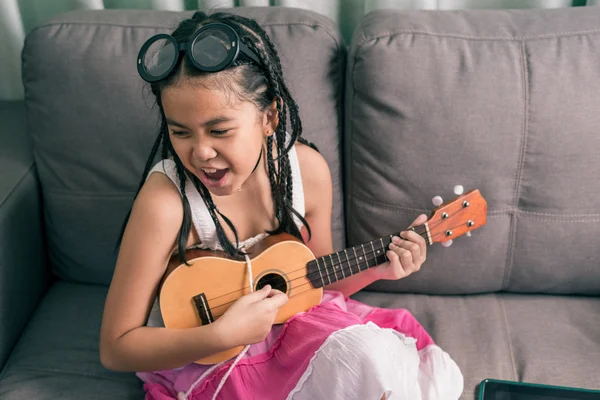Felice ragazza sorridente imparare a suonare la musica — Foto Stock