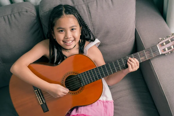 Boldog mosolygó lány tanulási játszani a gitár — Stock Fotó