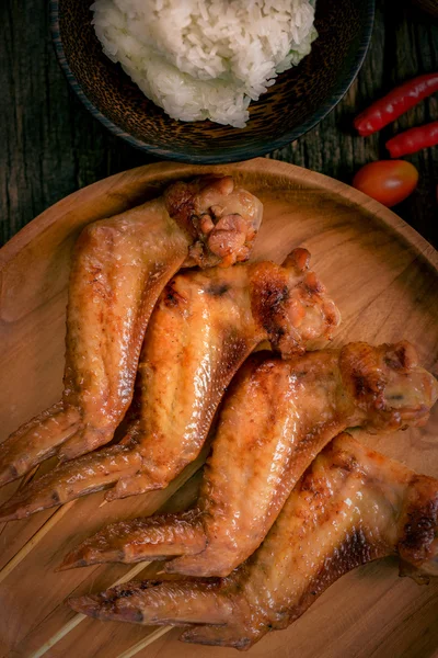 Asas de frango grelhadas em placa de madeira — Fotografia de Stock