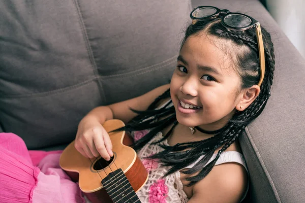 Happy fille souriante apprenant à jouer de la musique — Photo