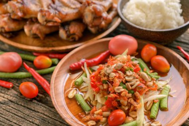 Famous Thai food, papaya salad and grilled chicken  clipart