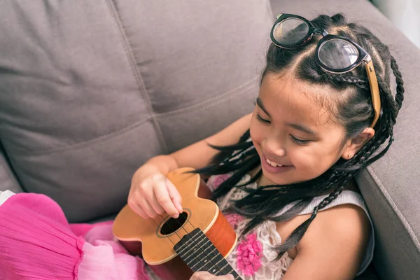 Joyeux sourire fille apprendre à jouer le Ukulele — Photo