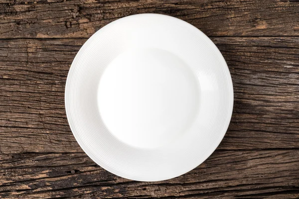 Empty white plate on wooden table — Stock Photo, Image