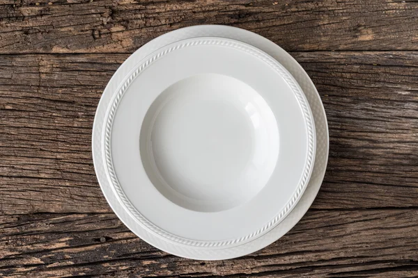 Empty white plate on wooden table — Stock Photo, Image