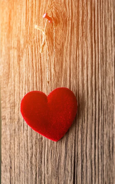 Love heart hanging on wooden texture background — Stock Photo, Image