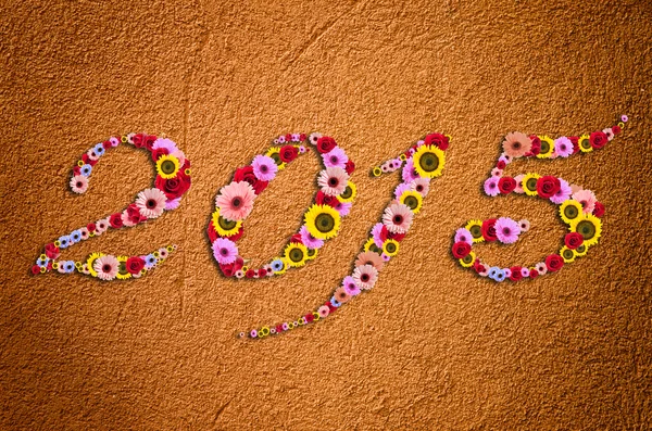 2015 Цветы на праздничном фоне на фрагменте современной грубой штукатурки — стоковое фото