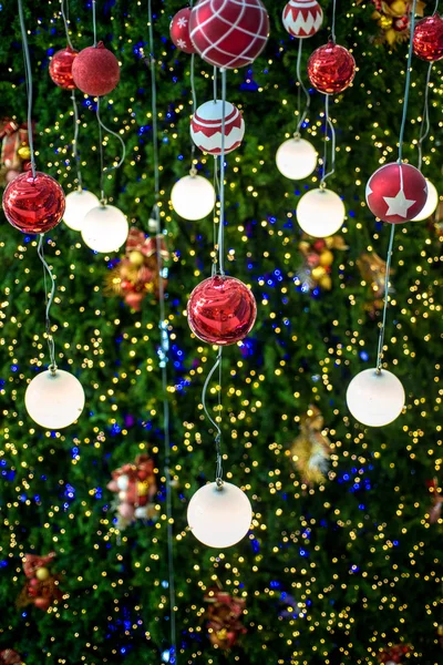 Christmas ball hanging on a Christmas tree with defocused lights — Stock Photo, Image