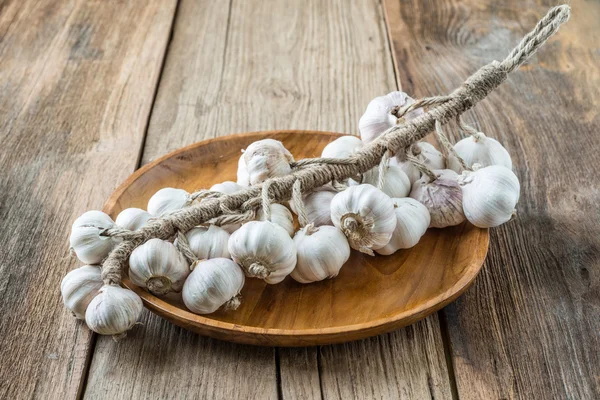 Bunch of dried garlic bulbs on a wooden Tray — Stock Photo, Image