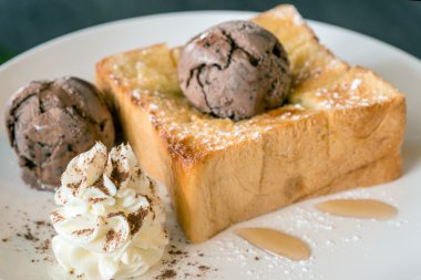 Bal tost beyaz çanak üzerinde çikolatalı dondurma ile 