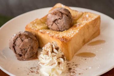 Bal tost beyaz çanak üzerinde çikolatalı dondurma ile 