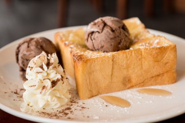 Bal tost beyaz çanak üzerinde çikolatalı dondurma ile 