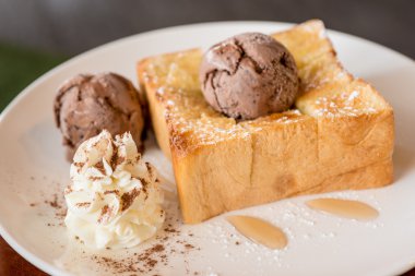 Bal tost beyaz çanak üzerinde çikolatalı dondurma ile 