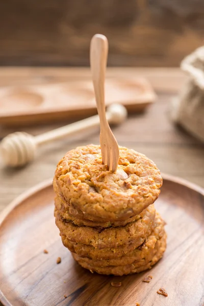 Vork zetten gestapelde cookies en hout schotel — Stockfoto