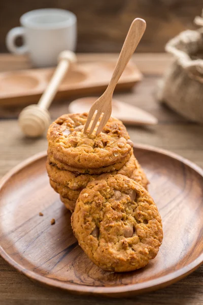 Fork colocar em cookies empilhados e prato de madeira — Fotografia de Stock