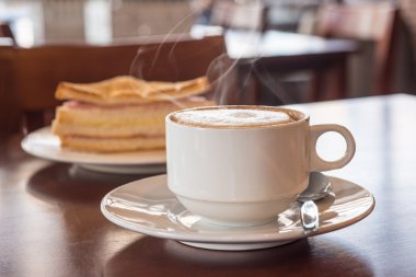 kahve dükkanında bir sandviç ile kahve fincanı closeup