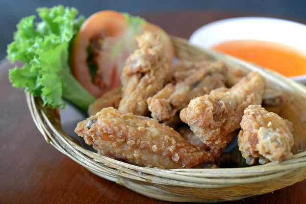 Fresh fried chicken on a wood basket set on a wood table — Stock Photo, Image