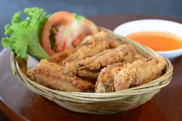 Frango frito fresco em uma cesta de madeira colocada em uma mesa de madeira — Fotografia de Stock