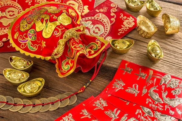 Китайский новый год украшения, китайский красный мешок и золотые слитки — стоковое фото